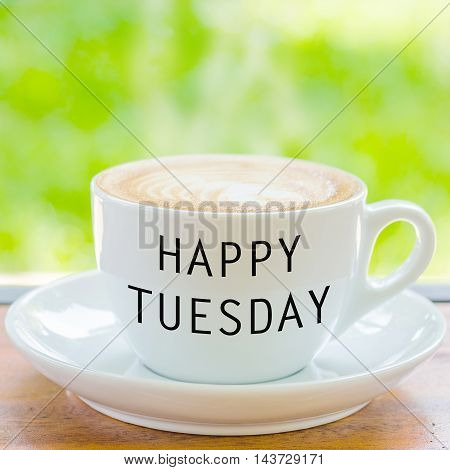 Happy Tuesday on coffee cup over natural background