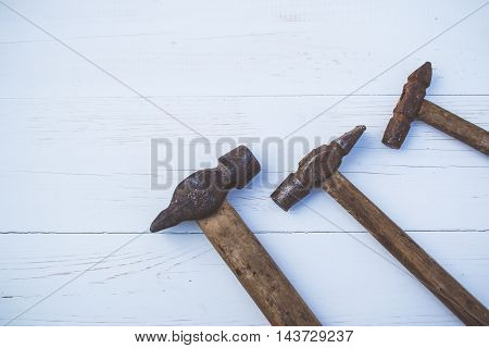 Set of old and rusty hammers on blue background
