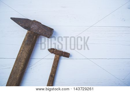 Set of old and rusty hammers on blue background