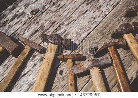 Set of old and rusty hammers on wooden background