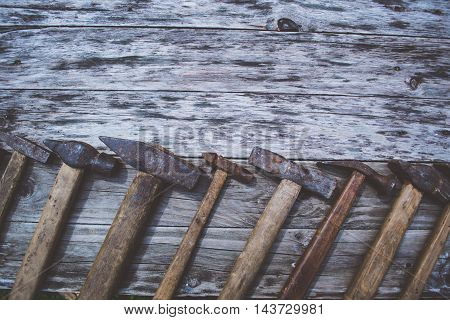 Set of old and rusty hammers on wooden background