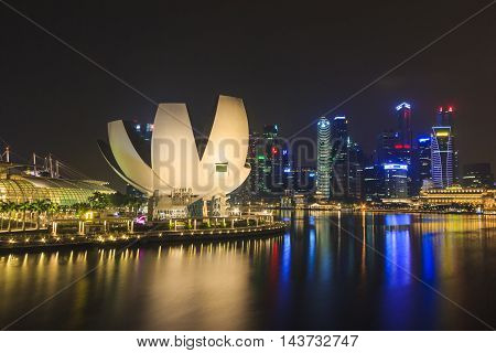 SINGAPORE SINGAPORE - SEPTEMBER 28 2013 : Night view of the Art Science Museum in front of Marina Bay Sands located at Marina Bay a famous tourist attractions in Singapore.