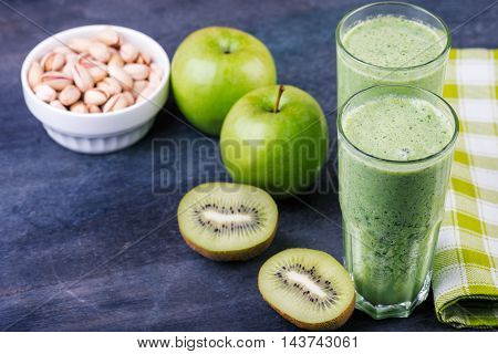 green smoothie with spinach kiw iand apple on a dark background selective focus