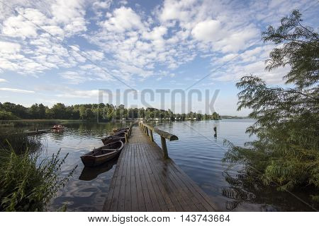 Small Wooden Bridge and Boats on Faarup Lake in Denmark