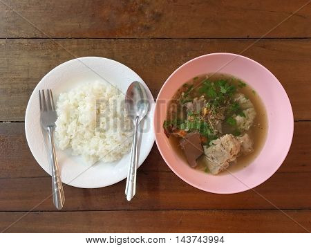 soup and rice. Hot soup with pork on wooden table.