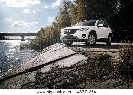 Saratov, Russia - August 30, 2014: Car Mazda CX-5 stand on asphalt countryside road near river at daytime
