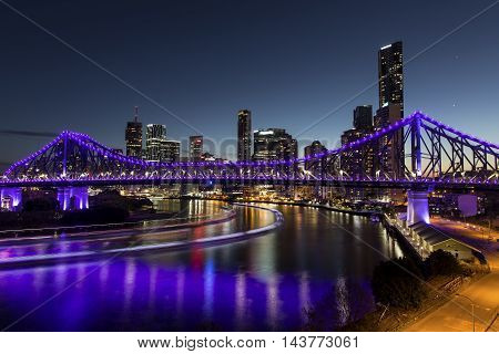 BRISBANE, AUSTRALIA - AUGUST 21 2016: Story Bridge at blue hour with light trails from the Brisbane City Cat ferries - purple lights