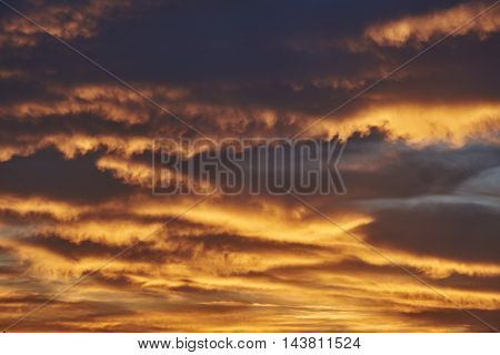 Rain cumulus clouds sundown. Clouds of orange and golden. Background