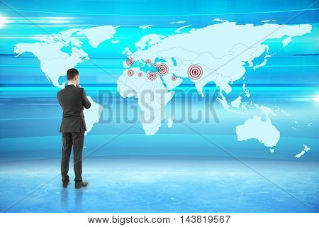 Thoughtful businessman looking at map with targets on abstract blue background. Geo targeting concept. 3D Rendering