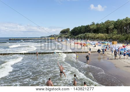 USTRONIE MORSKIE - AUGUST 15: Tourists enjoy the sunny weather and relaxing on the Baltic sea beach on 15 August 2016 in Ustronie Morskie, Poland.