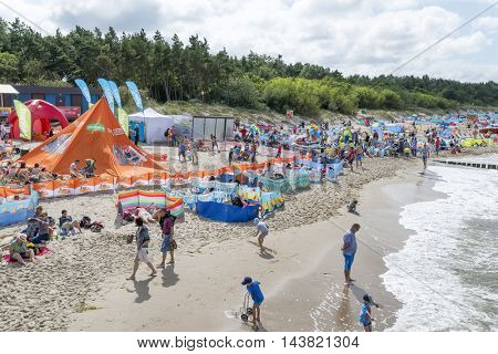 USTRONIE MORSKIE - AUGUST 15: Tourists enjoy the sunny weather and relaxing on the Baltic sea beach on 15 August 2016 in Ustronie Morskie, Poland.