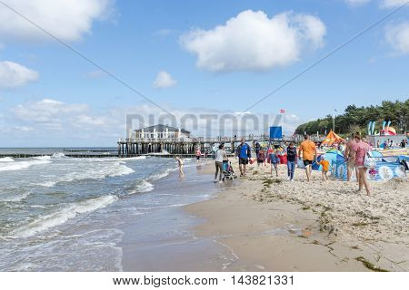 USTRONIE MORSKIE - AUGUST 15: Tourists enjoy the sunny weather and relaxing on the Baltic sea beach on 15 August 2016 in Ustronie Morskie, Poland.