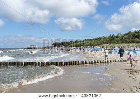 USTRONIE MORSKIE - AUGUST 15: Tourists enjoy the sunny weather and relaxing on the Baltic sea beach on 15 August 2016 in Ustronie Morskie, Poland.