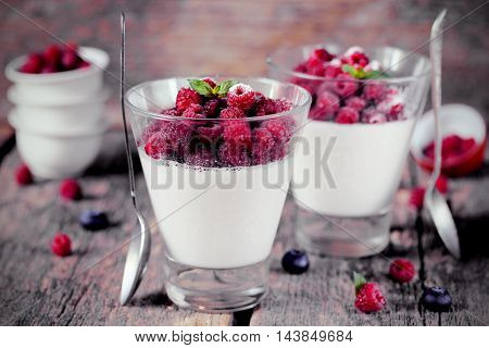 Panna cotta Italian dessert with berries raspberries in a rustic style toning selective focus