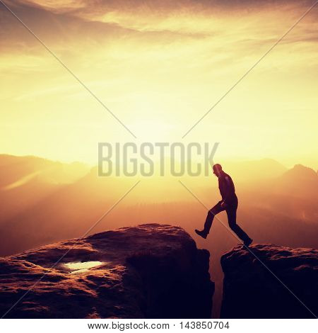 Silhouette Of Jumping Man And Beautiful Sunset Sky. Vintage Effect