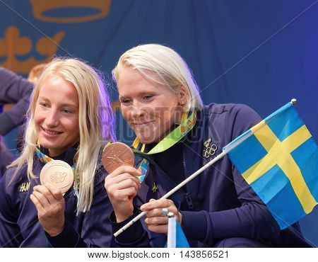 STOCKHOLM SWEDEN - AUG 21 2016: Happy swedish female wrestler Sofia Mattson and Jenny Fransson showing their medals when swedish olympic athletes are celebrated in Kungstradgarden StockholmSwedenAugust 212016