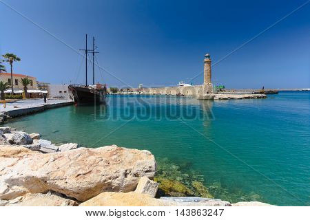 Rethymnon, Island Crete, Greece, - July 1, 2016: View of the harbor with lighthouse and the old sailing ship. Rethymnon is an old historic town on the northern coast of the island Crete.