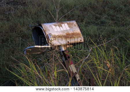 Derelict mailbox sits empty with door open.