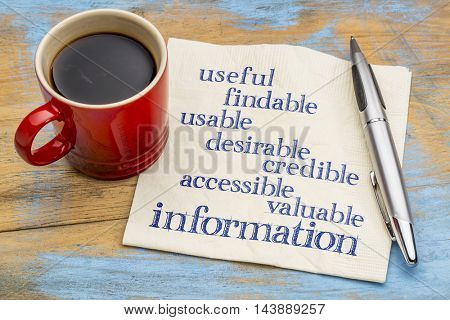 user experience concept - attributes of information important for usability and user experience on a napkin with a cup of coffee