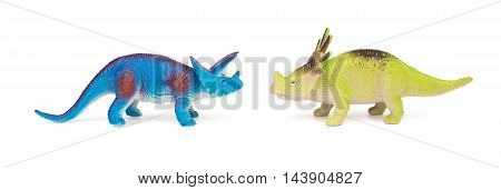 blue triceratops and green styracosaurus toys on a white background