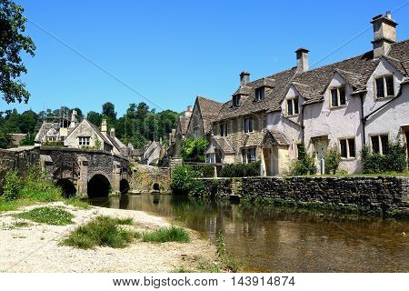 CASTLE COMBE, UNITED KINGDOM - JULY 20, 2016 - Stone cottages alongside the river Bybrook Castle Combe Wiltshire England UK Western Europe, July 20, 2016.