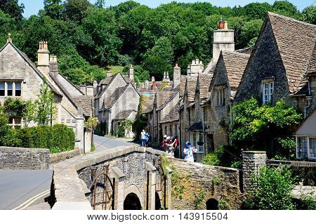 CASTLE COMBE, UNITED KINGDOM - JULY 20, 2016 - Stone bridge over the river Bybrook with cottages to the rear Castle Combe Wiltshire England UK Western Europe, July 20, 2016.