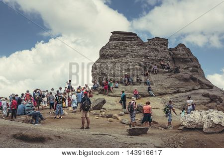 Bucegi Mountains Romania - August 6 2016: Tourists come to contemplate meditate or rest at Sphinx the legendary megalith with human face likeness located at 2216 m altitude in Bucegi Mountains.