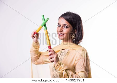 Indian beautiful young girl with garba sticks on Indian Festival Navratri, isolated on white background