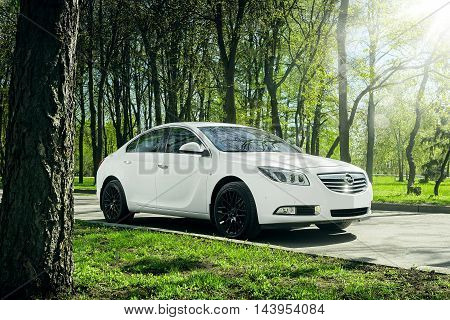 Moscow, Russia - May 07, 2015: Car Opel Insignia stand on asphalt road in green forest at daytime