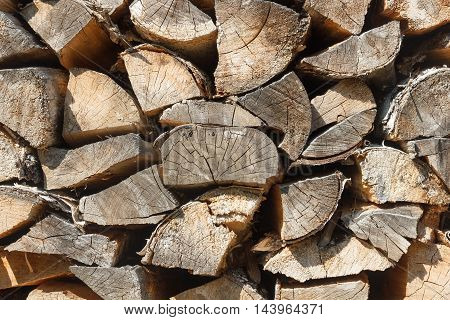 Woodpile texture of birch wood. Background of rustic style. Chopped cordwood stacked and ready for winter.