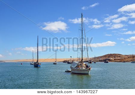 LUDERITZ NAMIBIA - JAN 26 2016: Sailing yachts in port of Luderitz at sunrise Luderitz is a harbour town lying on one of the least hospitable coasts in Africa