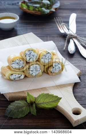A photo of fried vegetable rolls filled with cream cheese on a cutting board