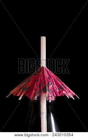 Straw For Cocktails With An Umbrella In The Neck Of A Bottle