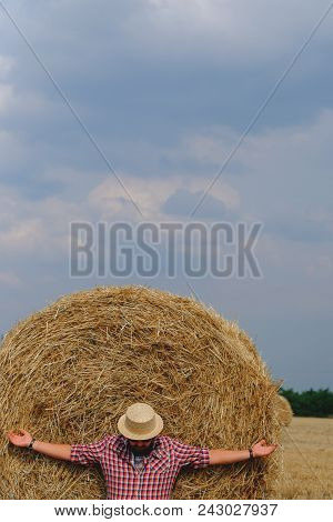 Man Resting After Hay Harvesting In Haystacks
