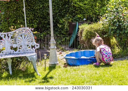 Adorable Little Girl Playing In A Sandbox.
