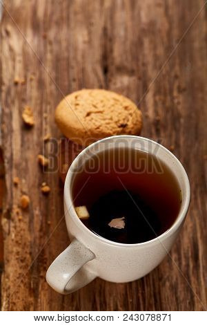 White Porcelain Mug Of Black Tea Or Earl Grey And Pile Of Sweet Cookies On Flat Piece Of Wood Over R