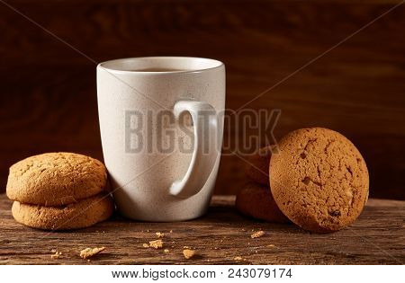 White Porcelain Mug Of Black Tea Or Earl Grey And Pile Of Sweet Cookies On Flat Piece Of Wood Over R