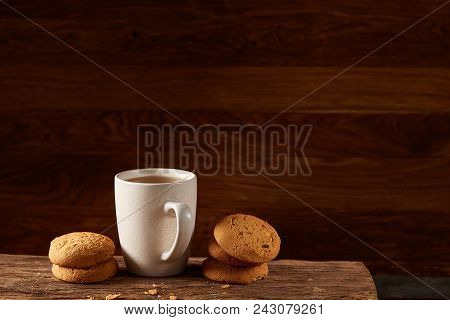 White Porcelain Mug Of Black Tea Or Earl Grey And Pile Of Sweet Cookies On Flat Piece Of Wood Over R