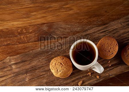 White Porcelain Mug Of Black Tea Or Earl Grey And Pile Of Sweet Cookies On Flat Piece Of Wood Over R