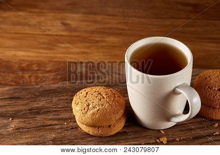White Porcelain Mug Of Black Tea Or Earl Grey And Pile Of Sweet Cookies On Flat Piece Of Wood Over R