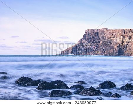 Amazing Sunset, Talisker Bay On The Isle Of Skye In Scotland. Foamy Sea, Boulders And Large Cracked 