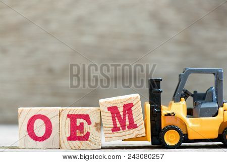 Toy Forklift Hold Letter Block M In Word Oem (abbreviation Of Original Equipment Manufacturer) On Wo