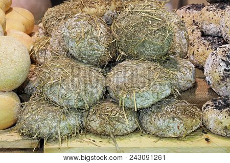 Seasoned Cheese Covered With Straw After Aging In A Wet Cave