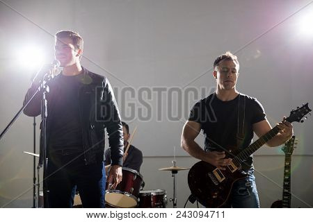 Lead Singer Singing With Guitarist Playing Electric Guitar On Stage At A Rock Concert
