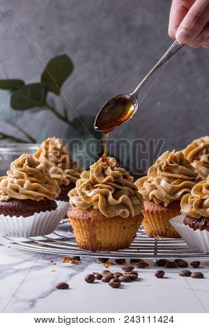 Fresh Baked Homemade Cupcakes With Coffee Buttercream And Pouring From Spoon Caramel Standing On Coo