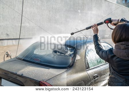 Young Woman Washing Car At Self-service Carwash