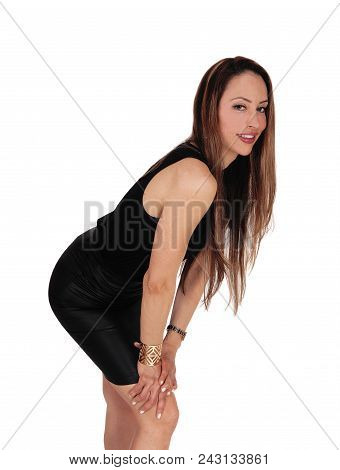 A Beautiful Woman In A Black Blouse And Leather Skirt Bending Forward
With Her Long Brunette Hair, I