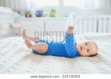Adorable Baby Girl Lying On Bed In Nursery
