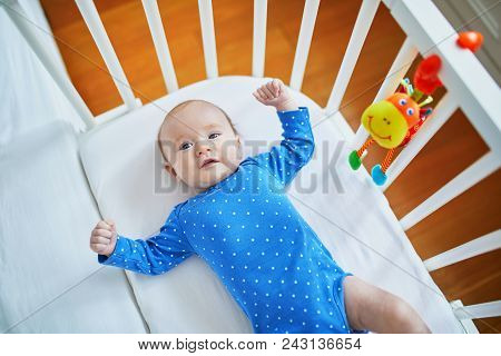 Baby Girl Lying In Co-sleeper Attached To Parents' Bed