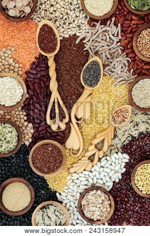 Dried super food background with grains, seeds, pulses & cereals loose and in love spoons. Foods high in omega 3, protein, antioxidants, smart carbohydrates, anthocyanins & fibre. Top view. 